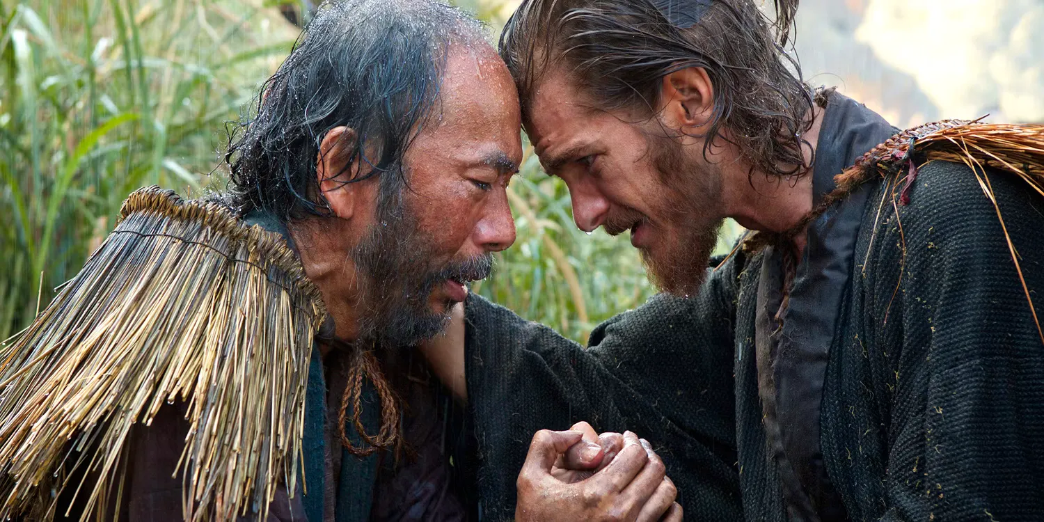 A Catholic priest leaning against a Japanese man in Silence Image