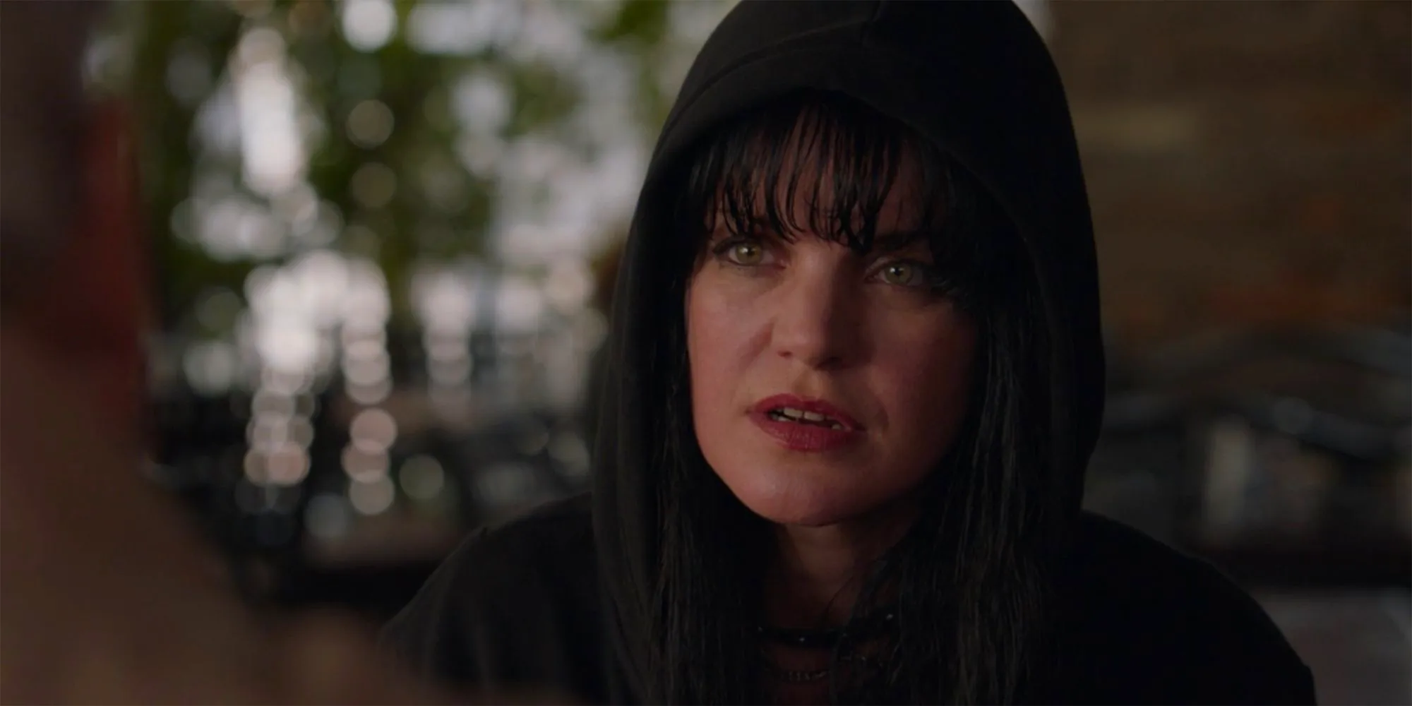 A close up of Abby Sciuto wearing a black hood and looking concerned in NCIS Image