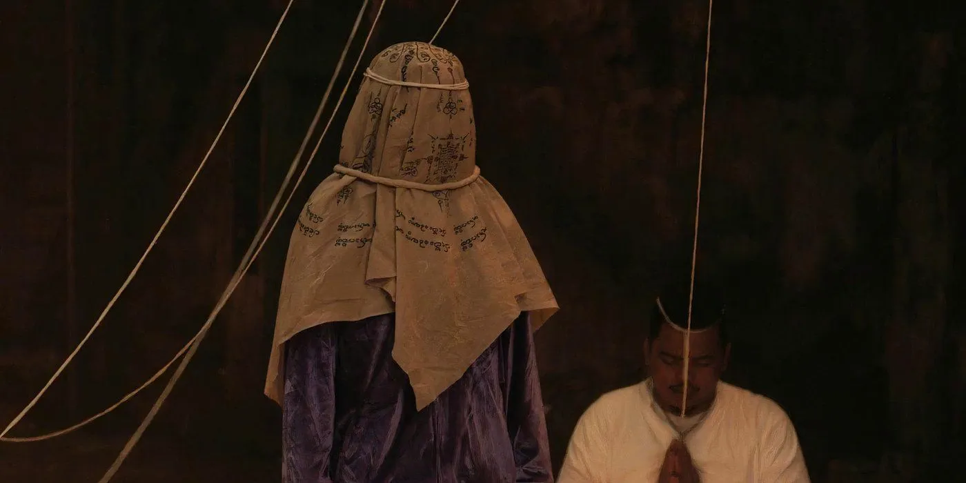 A creepy figure in a ceremonial head covering in the 2021 Thai horror movie The Medium Image