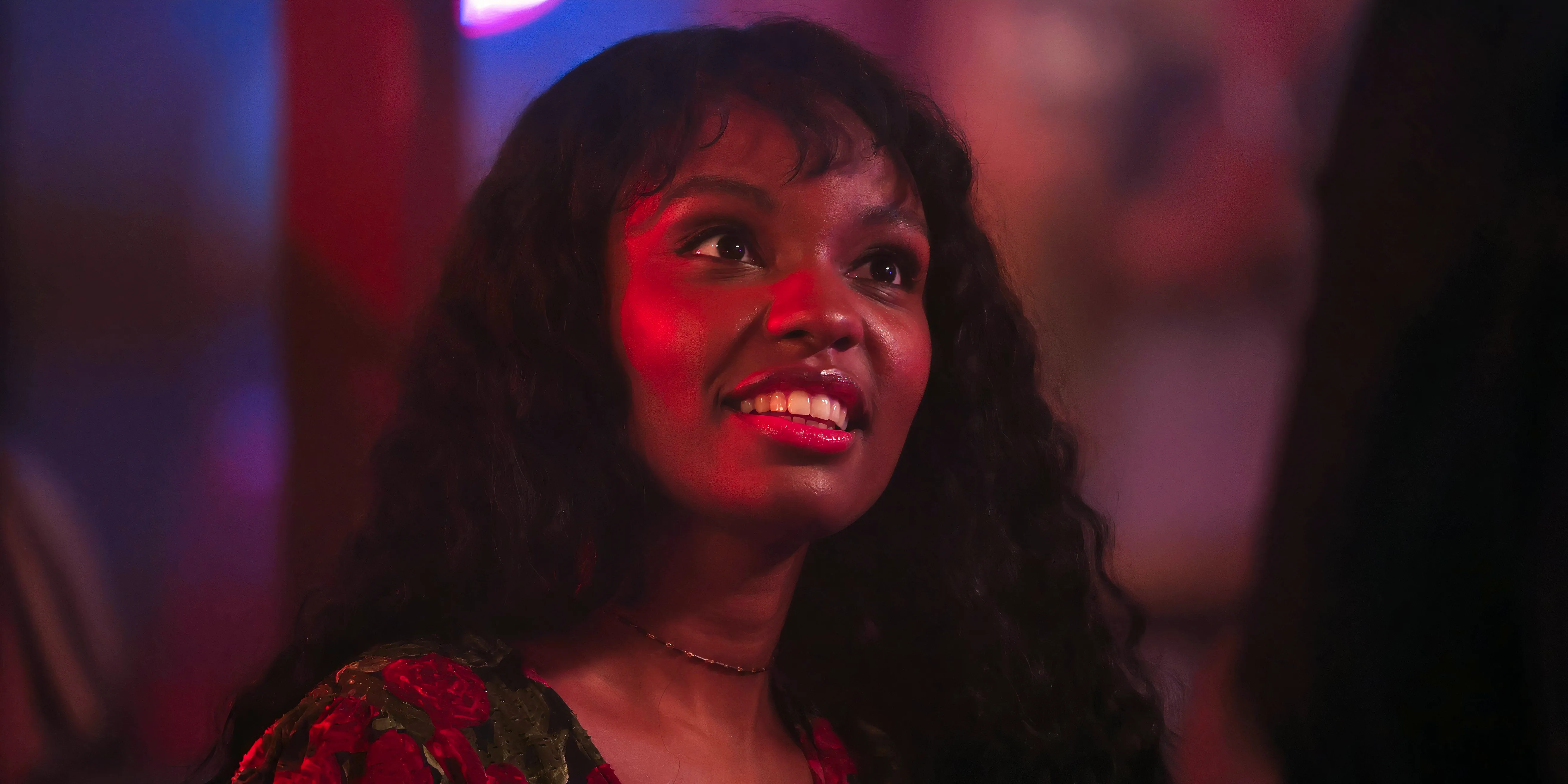 A flashback of Sierra McClain as Grace smiling at the bar in 9-1-1: Lone Star. Image