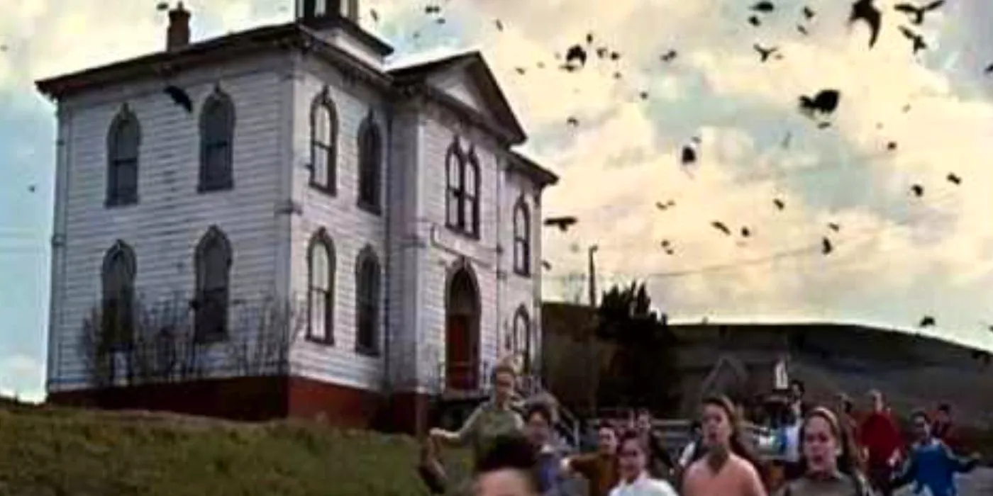 A group of people running away from a big house and a swarm of crows in The Birds (1963) Image