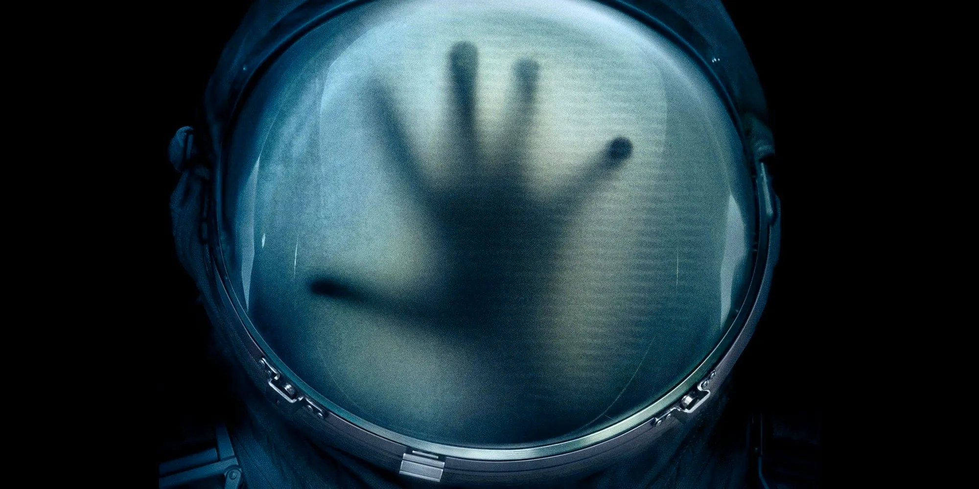 A hand inside an astronaut's helmet in 2017's Life. Image