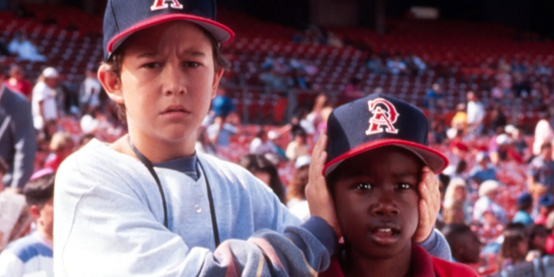 A kid with his hands over another kid's ears in Angels in the Outfield  Image