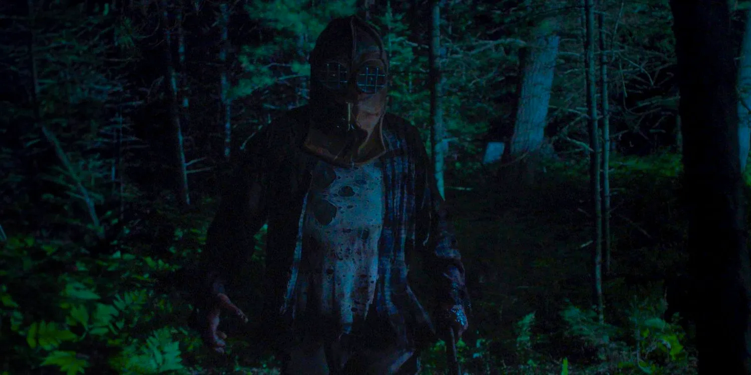 A masked killer in the middle of a dark forest from In a Violent Nature (2024) Image