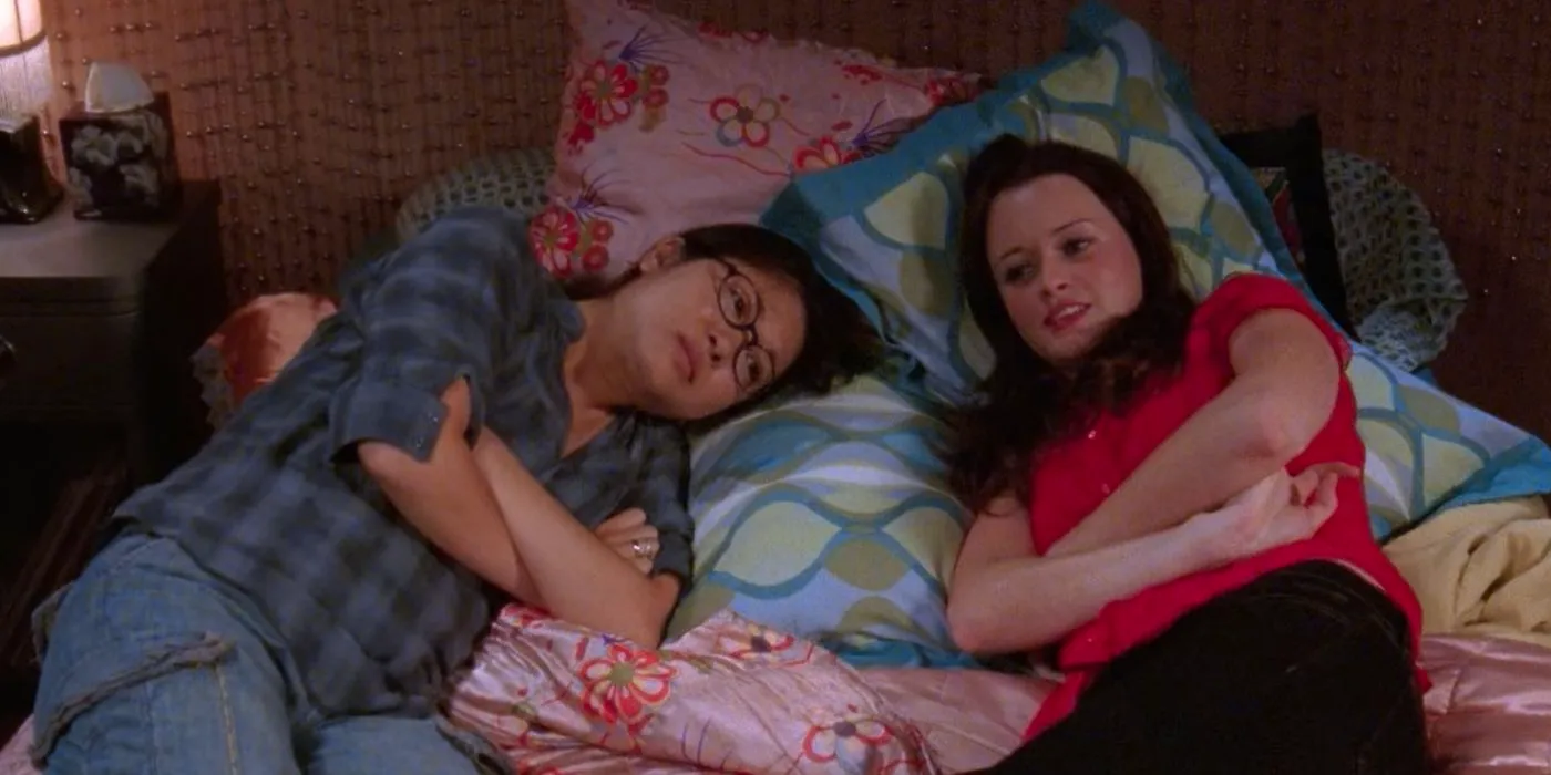 A pregnant Lane and Rory lying in bed together in Gilmore Girls Image