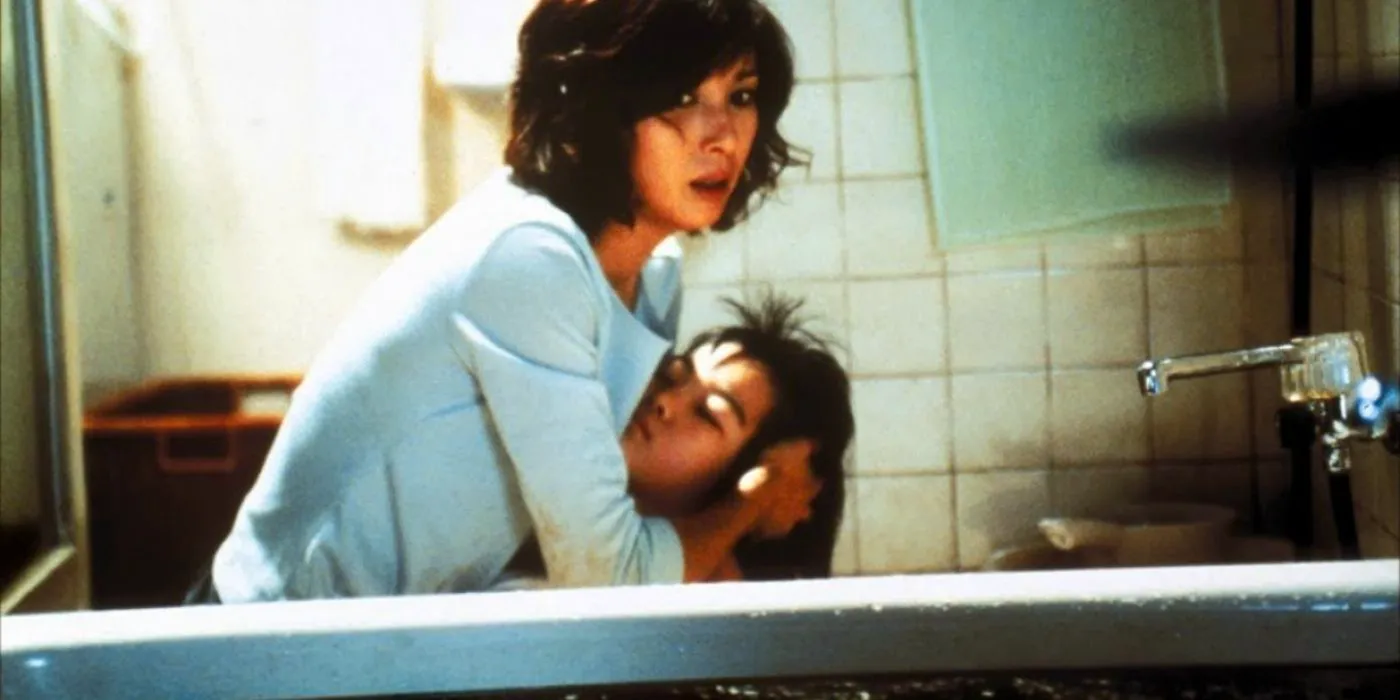 A woman holds her daughter in the bathtub in Dark Water. Image