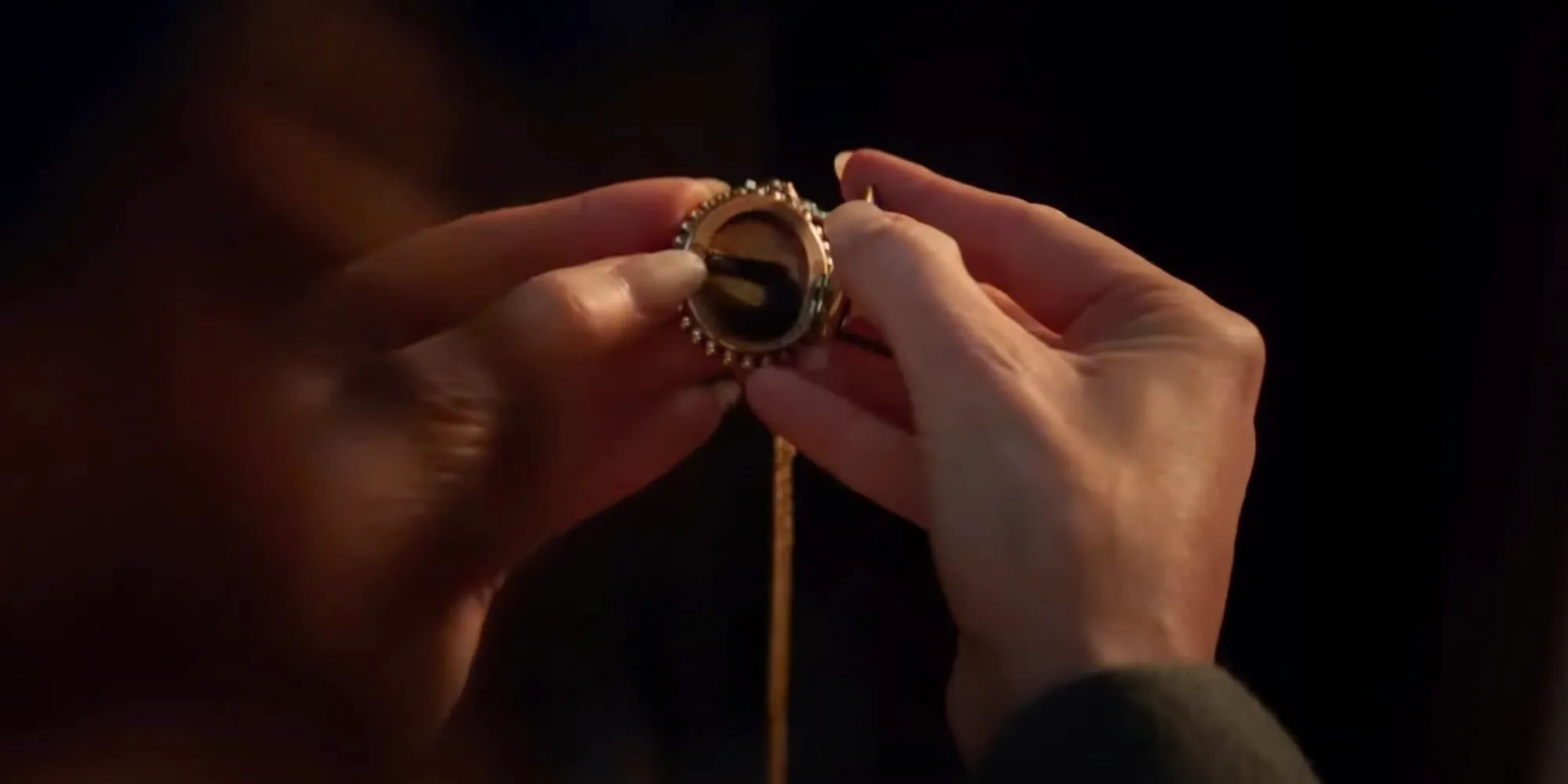 Agatha holding a locket with hair inside of it in Agatha All Along Image