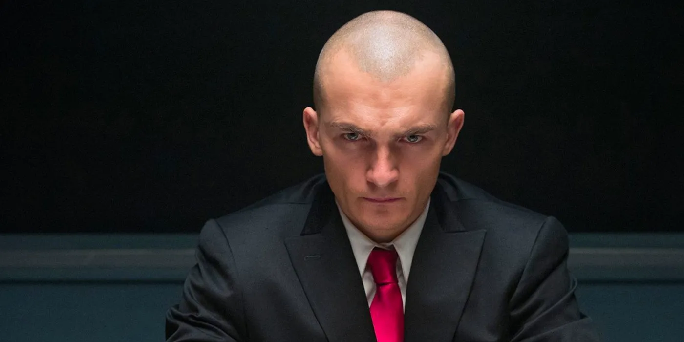 Agent 47 in his iconic suit and red tie being interrogated in Hitman: Agent 47 Image