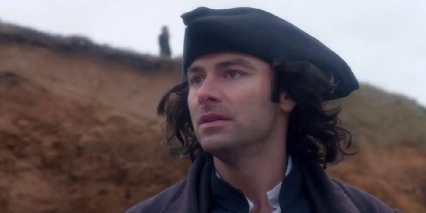 Aidan Turner as Captain Ross Vennor Poldark looking worried across a grassy landscape in Poldark. Image