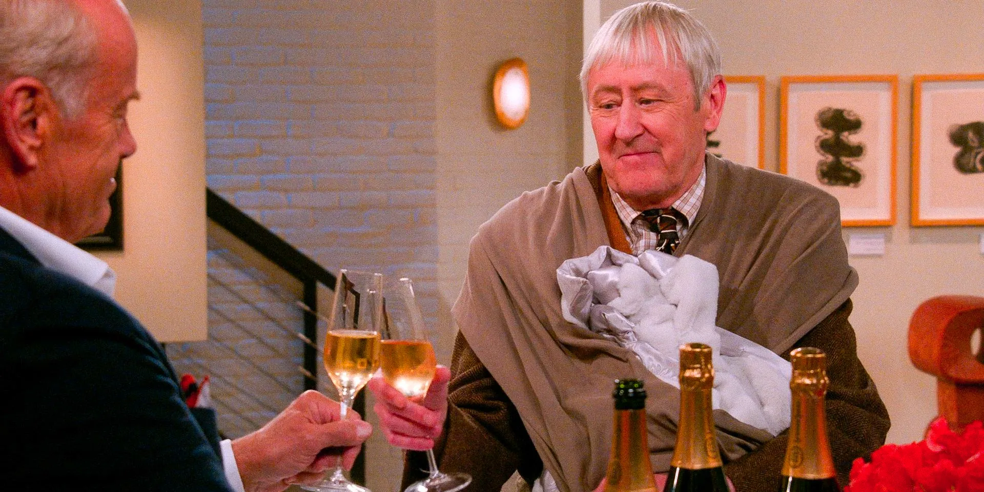 Alan (Nicholas Lyndhurst) toasts with Frasier (Kelsey Grammer) in Frasier Season 2 Episode 3. Image