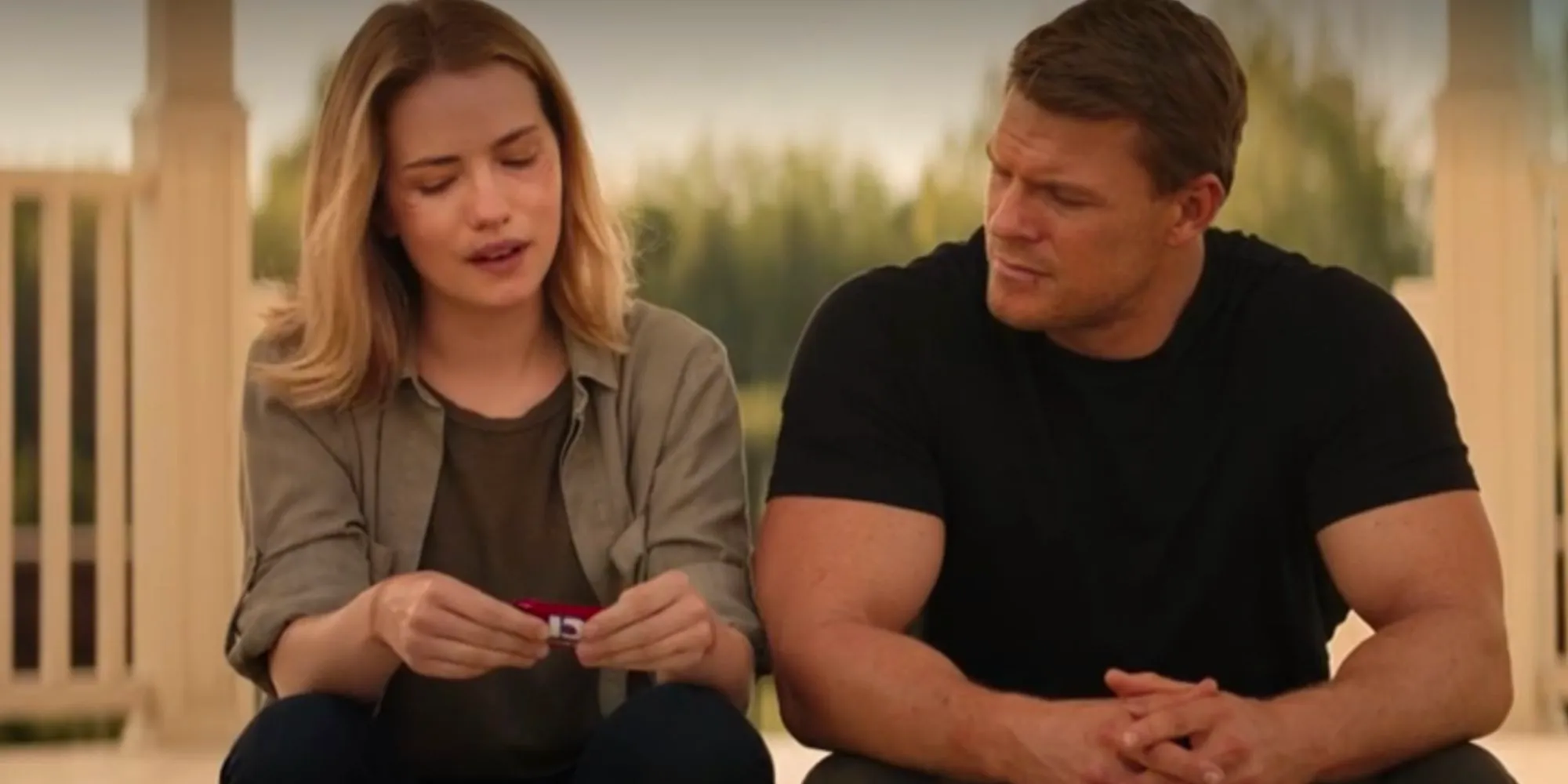 Alan Ritchson as Reacher and Willa Fitzgerald as Roscoe Conklin sitting next to each other in conversation Image