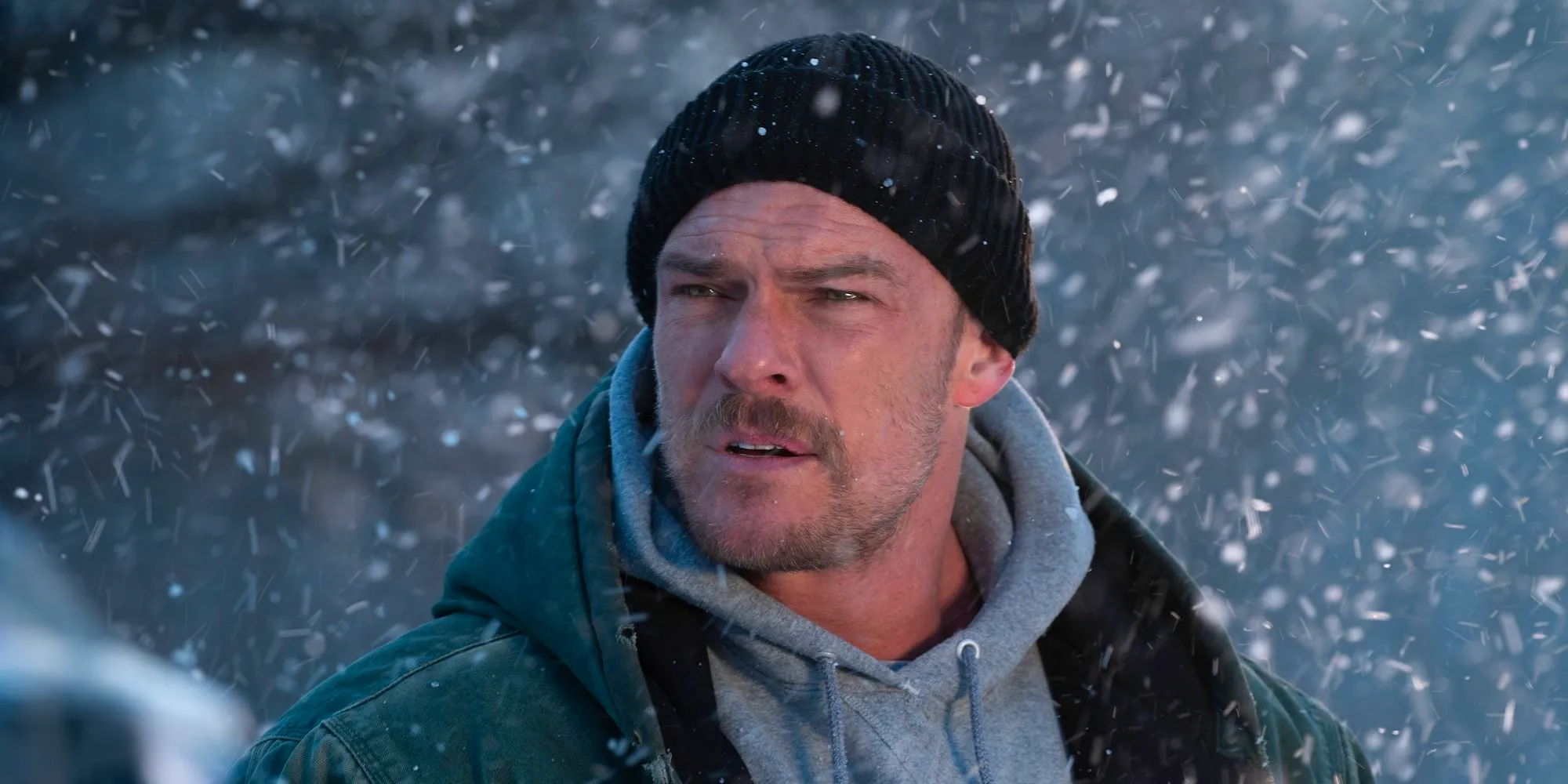 Alan Ritchson stands in the snow in Ordinary Angels Image