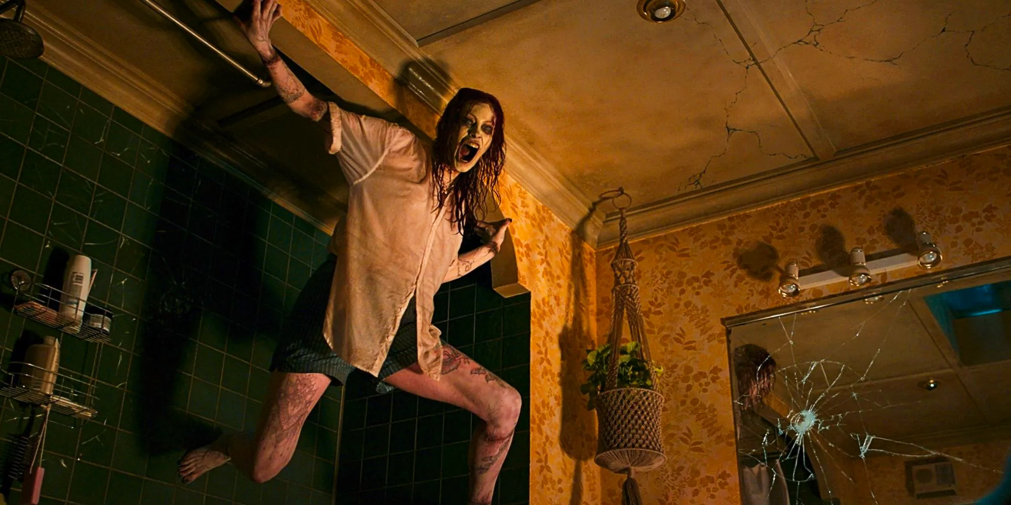 Alyssa Sutherland as Deadite Ellie screaming on a wall in Evil Dead Rise Image