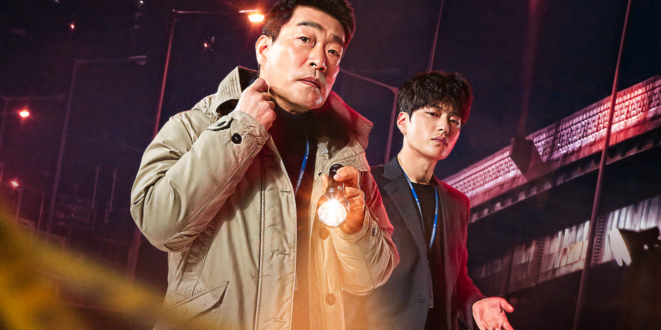 An older man carries a flashlight ahdead of a younger man in the K-drama The Good Detective Image