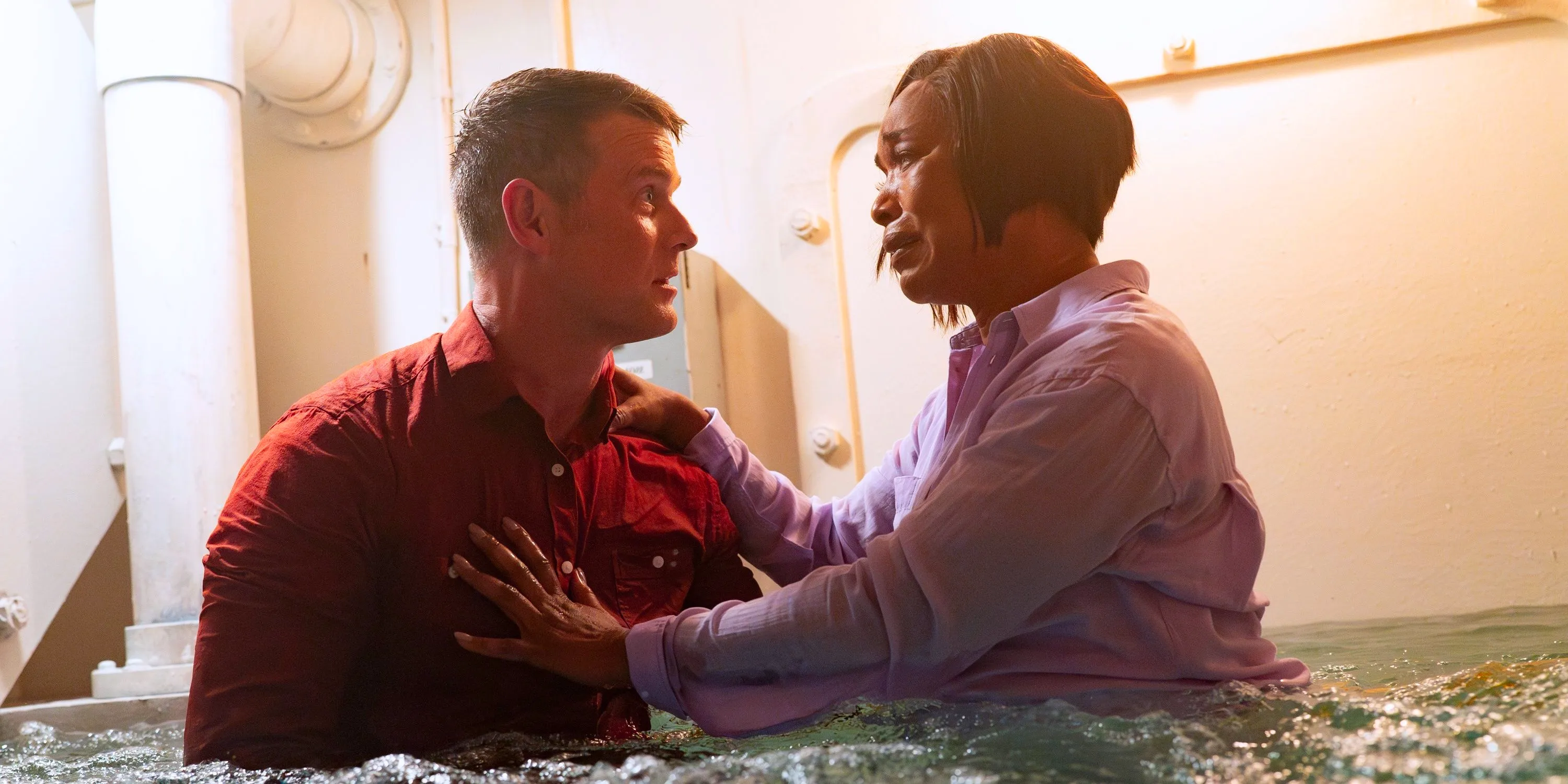 Angela Bassett as Athena Grant-Nash and Peter Krause as Bobby Nash holding each other in a flooding room in 9-1-1 season 7. Image