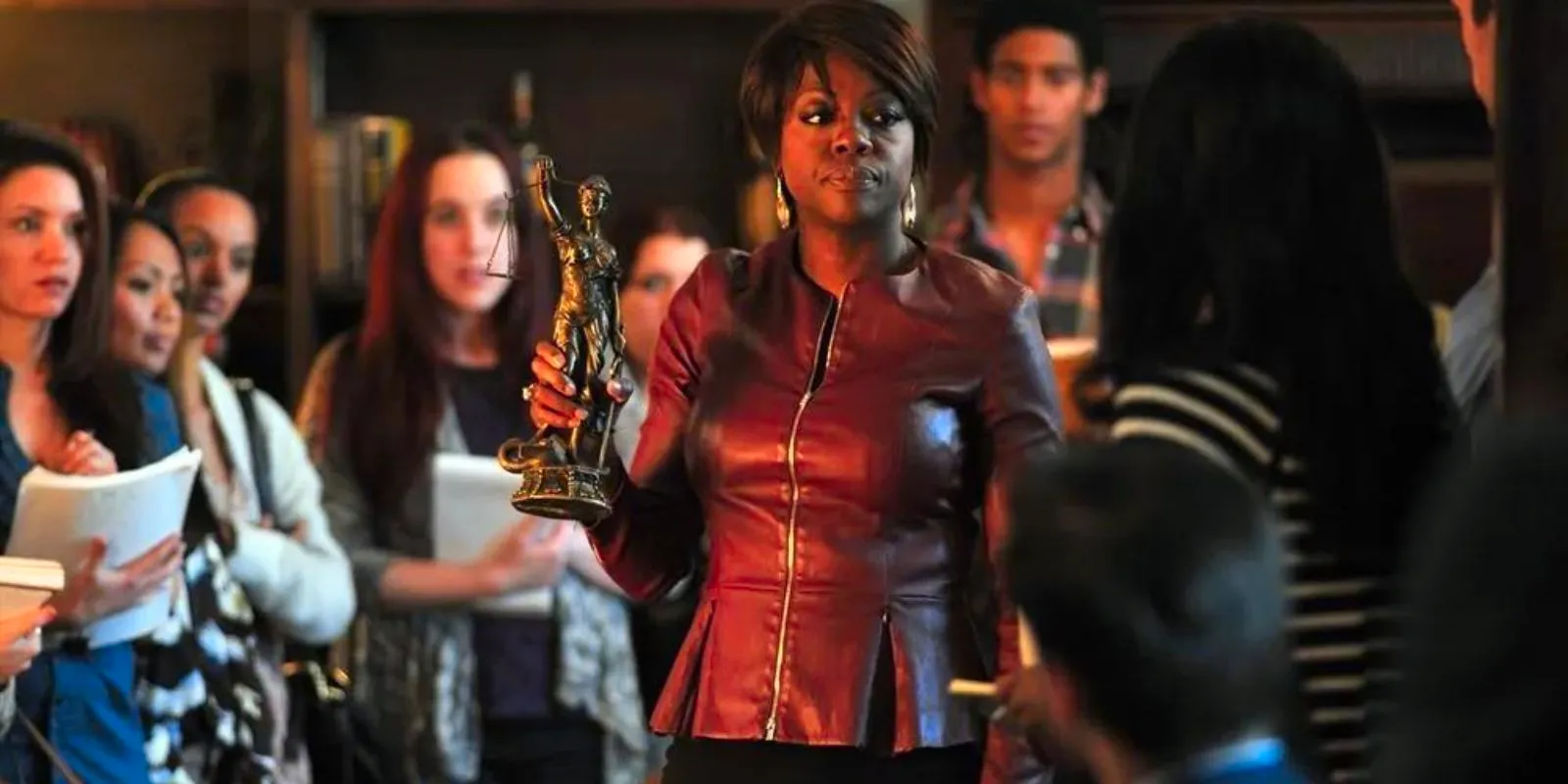 Annalise holds up Blind Lady Scales Of Justice Statue Image