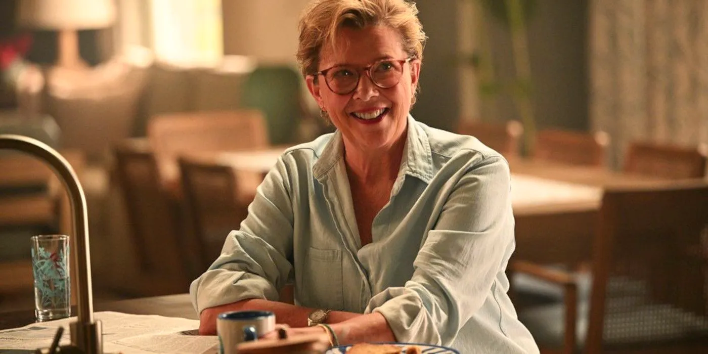 Annette Bening as Joy Delaney sitting at a table and smiling in Apples Never Fall Image