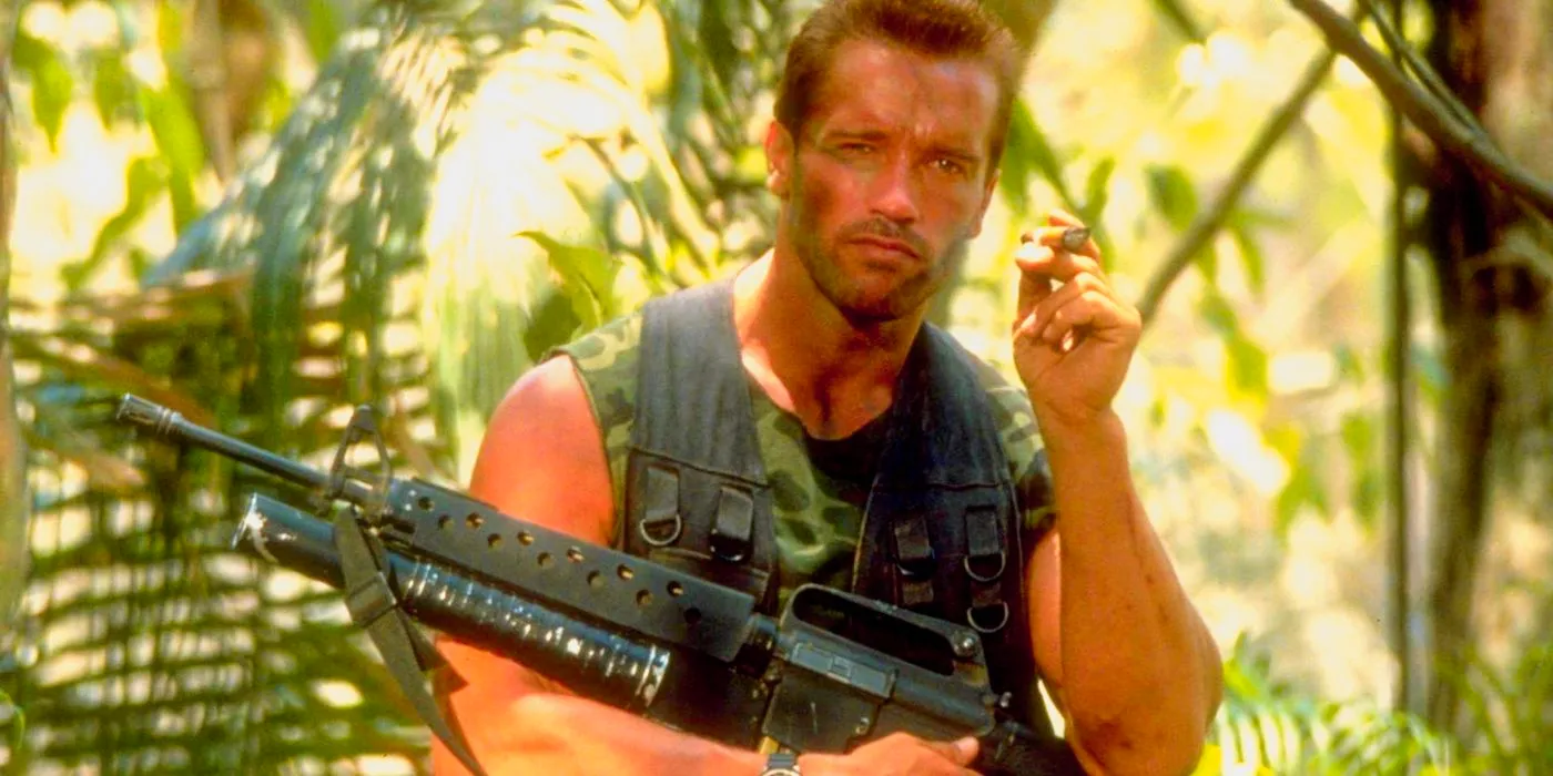 Arnold Schwarzenegger as Dutch with a gun in his lap in Predator Image