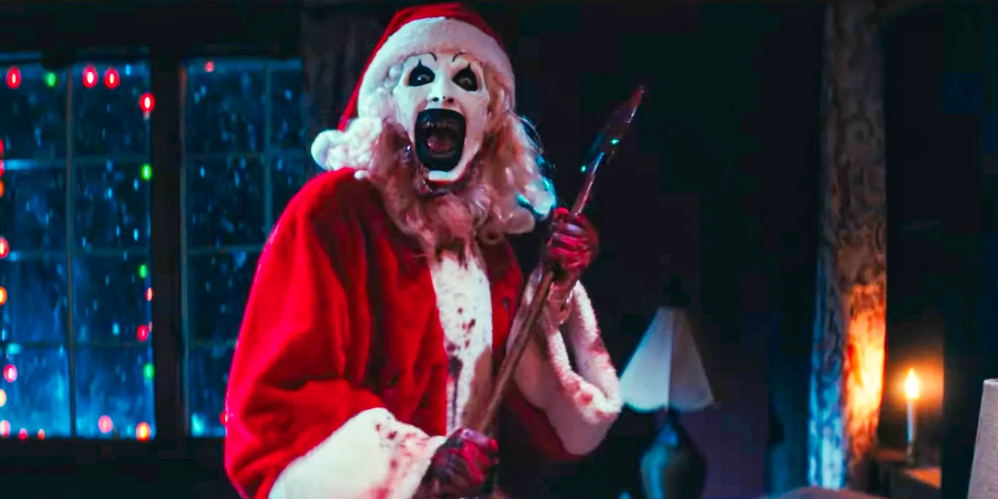 Art The Clown (David Howard Thornton) dressed as santa with a quite bloody axe in Terrifier 3 Image