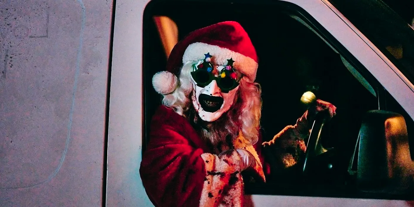 Art the Clown (David. Howard Thornton) wearing a santa suit and leaning out of a van in Terrifier 3. Image