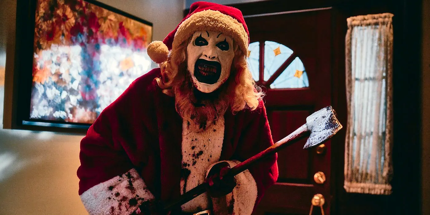 Art the Clown (David Howard Thornton) wearing a santa suit and wielding an axe in Terrifier 3 Image