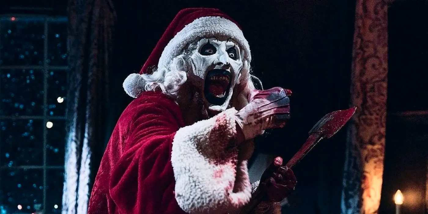 Art the Clown smiles while holding a bloody ax in Terrifier 3 Image