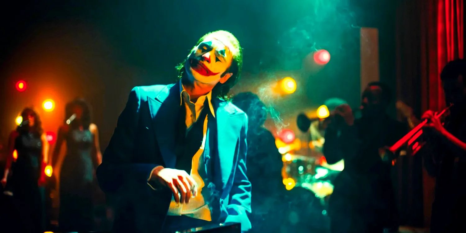 Arthur Fleck as the Joker (Joaquin Phoenix) smokes a cigarette while enjoying a music performance behind him in Joker: Folie à Deux Image