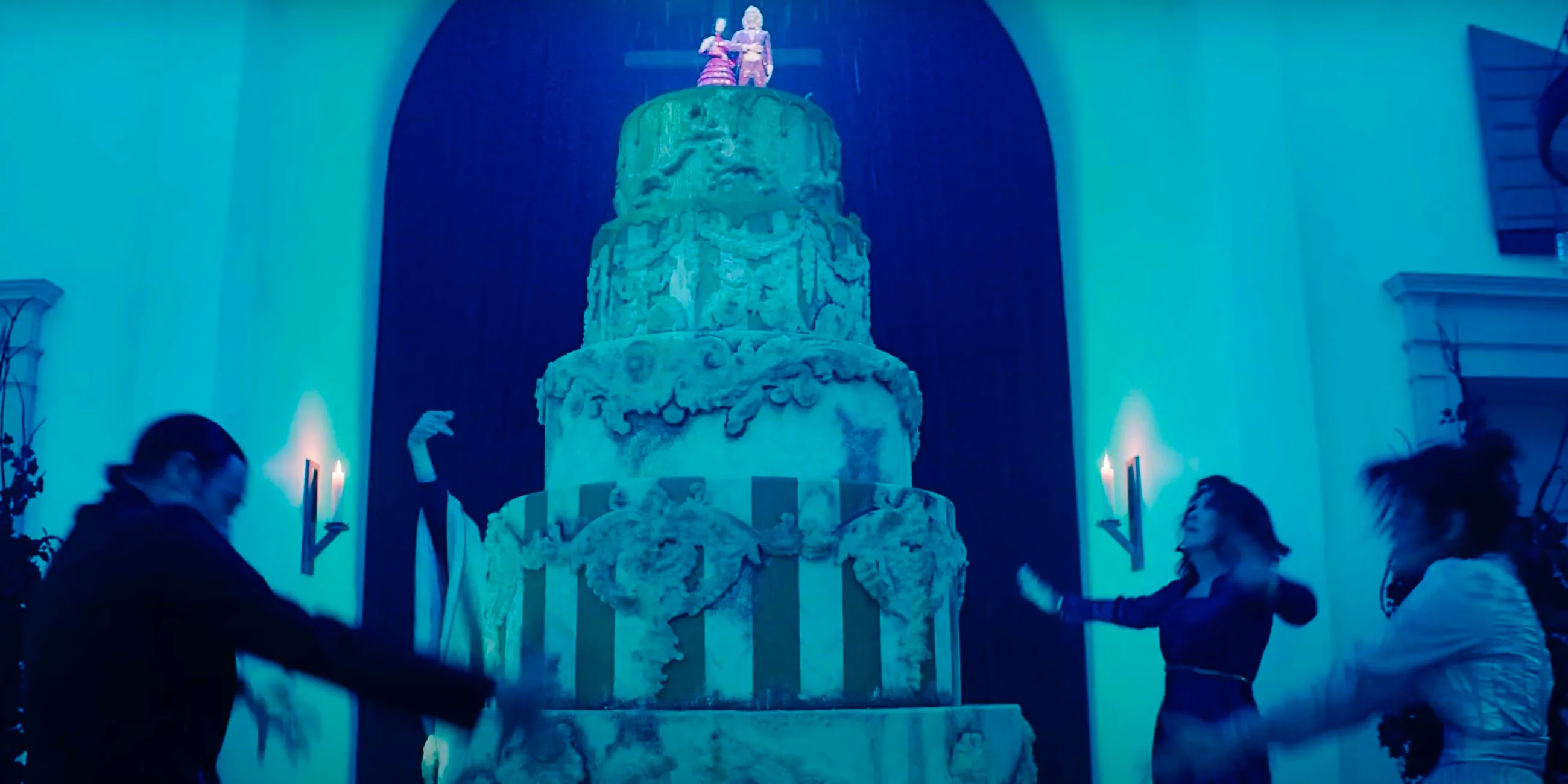 Astrid, Delia, and Rory dancing around the wedding cake in Beetlejuice 2 Image