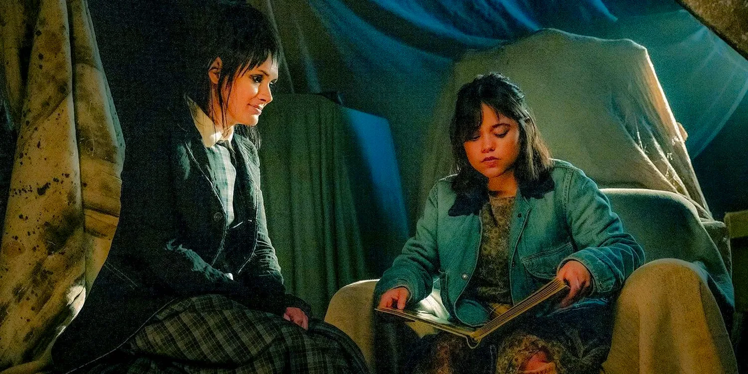 Astrid (Jenna Ortega) and Lydia (Winona Ryder) in the attic, looking at an old photo album in Beetlejuice Beetlejuice Image