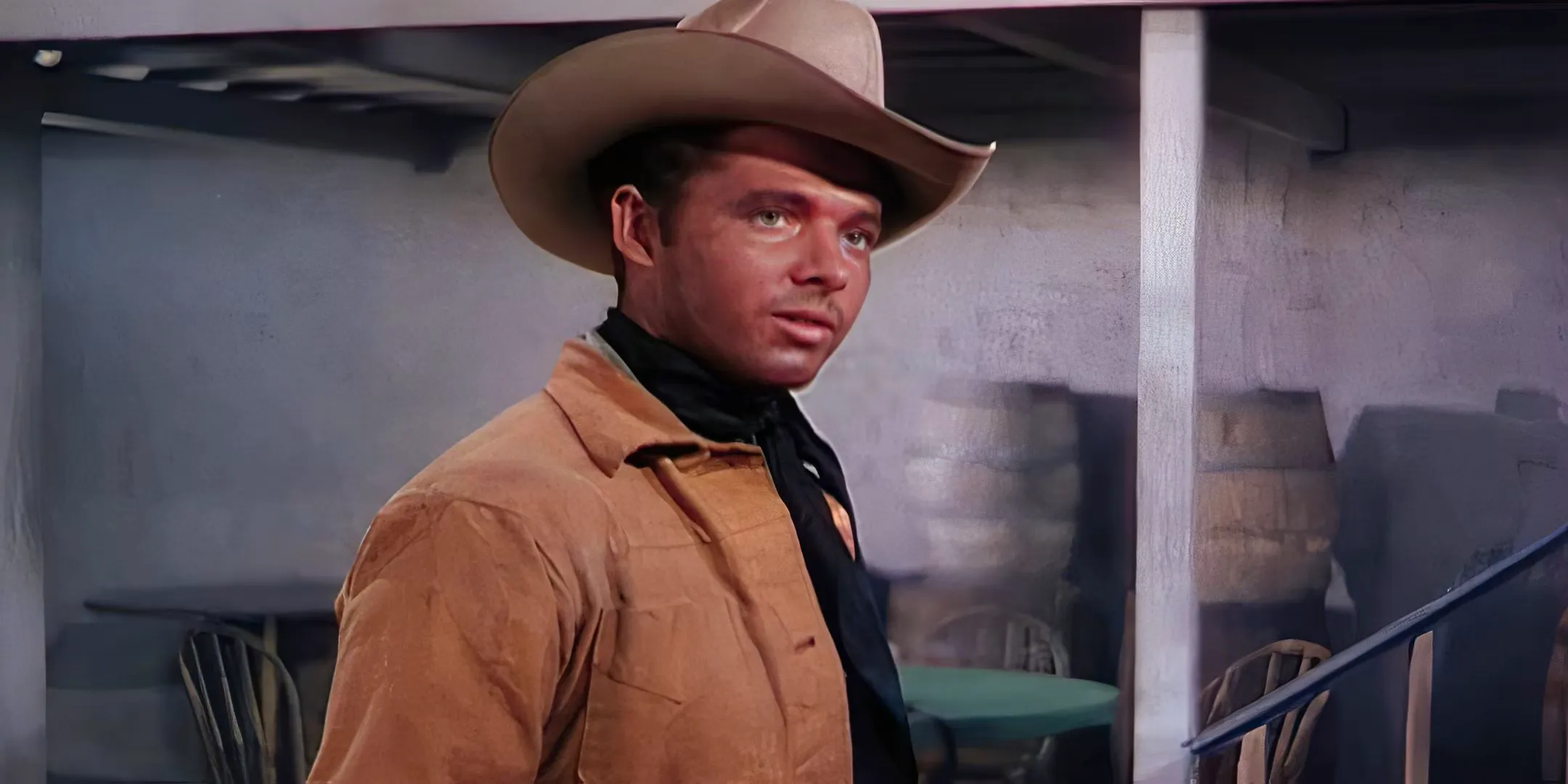 Audie Murphy stands outside and looks ahead.  Image