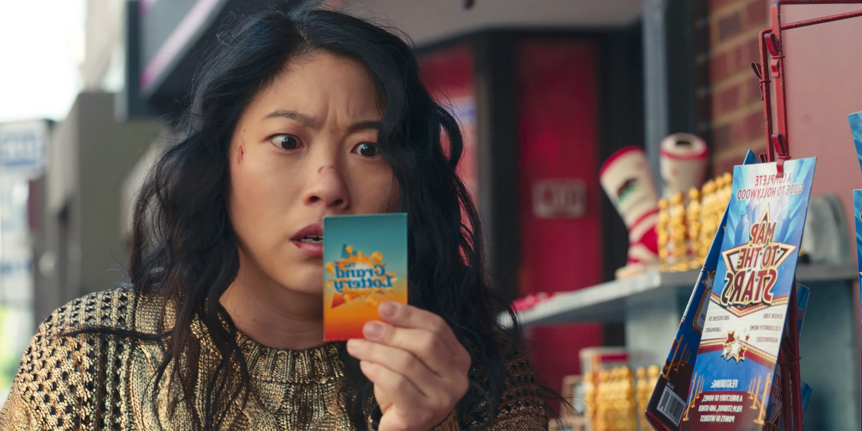 Awkwafina as Katie looking at a ticket in shock in Jackpot. Image