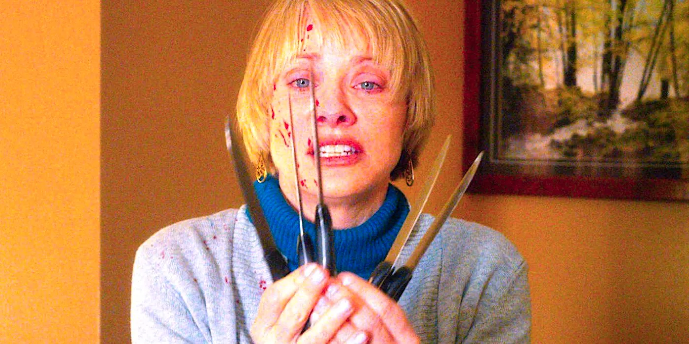 Barbara Crampton's Anne holds up numerous knives in We Are Still Here Image