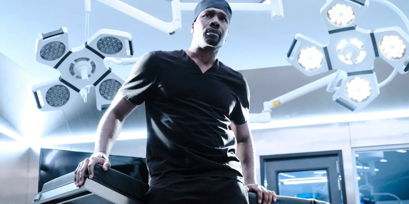 Barrett Cain (Morris Chestnut) leaning against his operating table in The Resident. Image