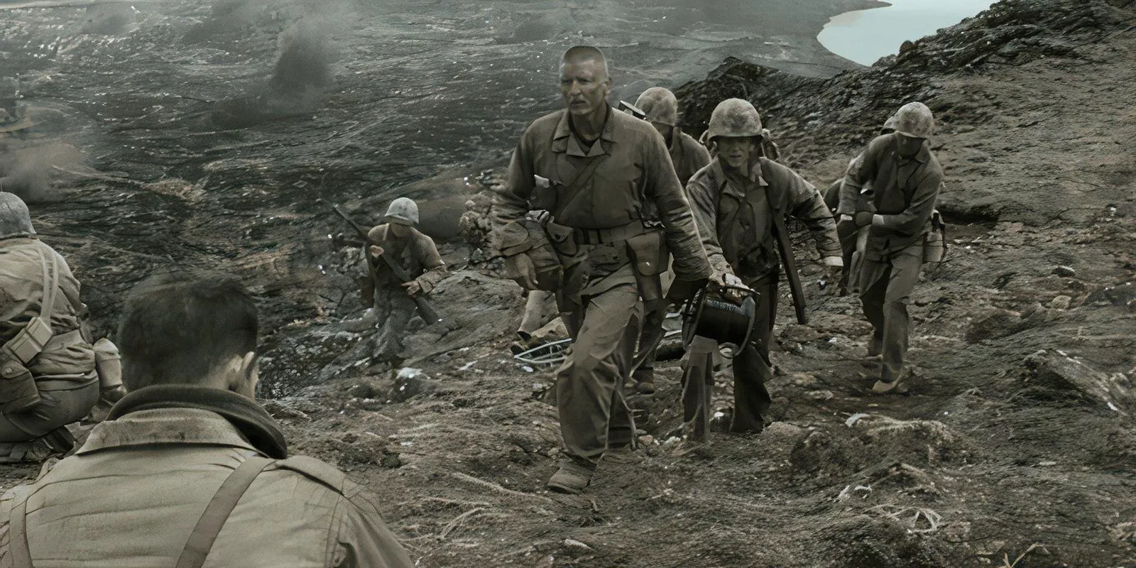 Barry Pepper walking through a battlefield with American Marines in Flags of Our Fathers Image