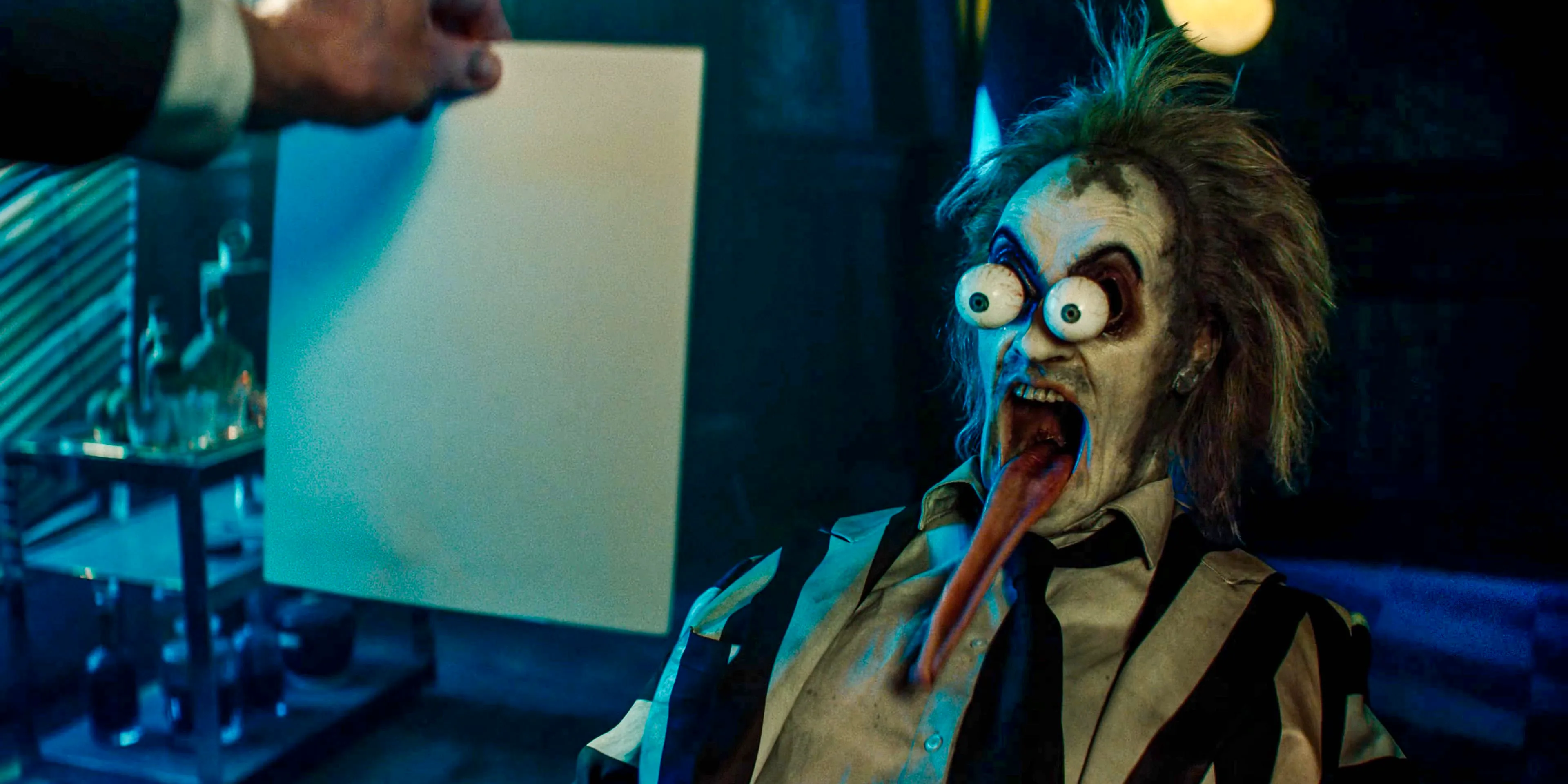 Beetlejuice (Michael Keaton) with googly eyes and a long, drooling tongue after being shown a picture of Delores in Beetlejuice Beetlejuice Image