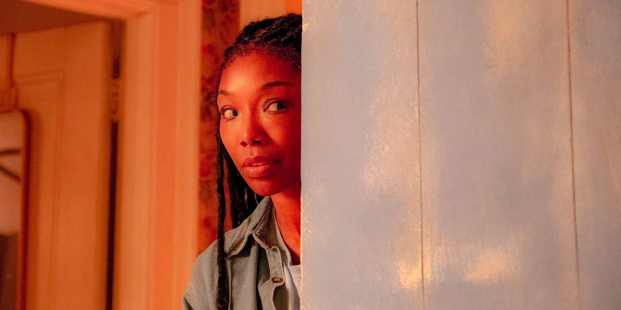 Belinda (Brandy Norwood) peeking out from behind the wall in The Front Room Image