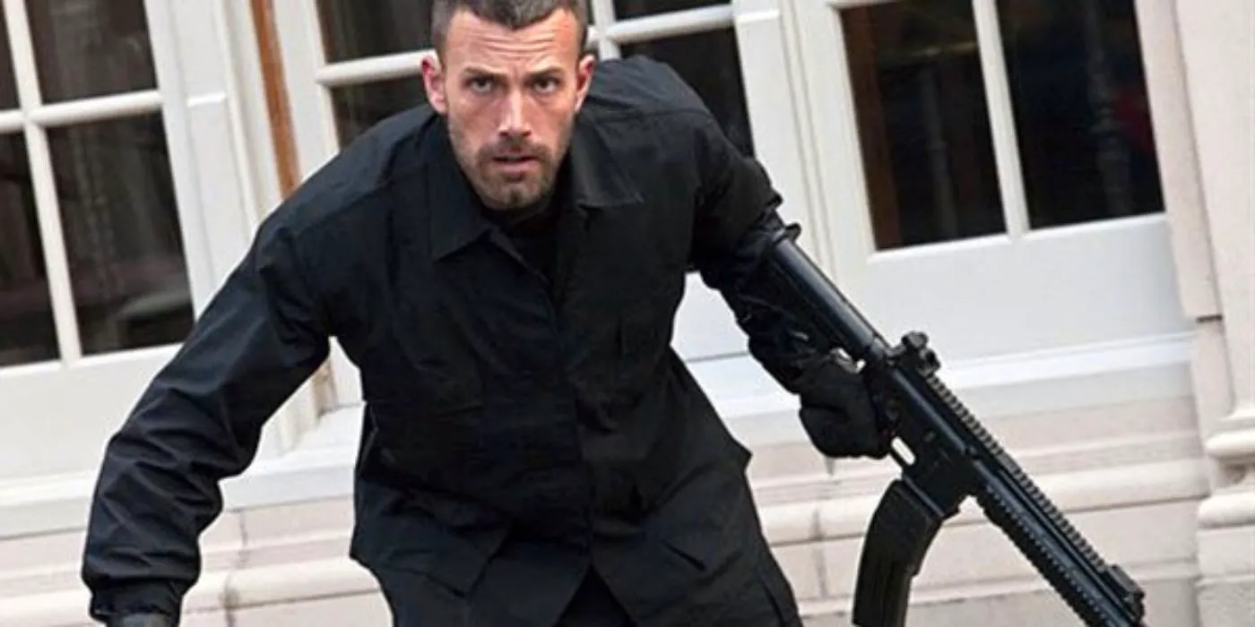 Ben Affleck, dressed in black, runs with a gun in hand. Image