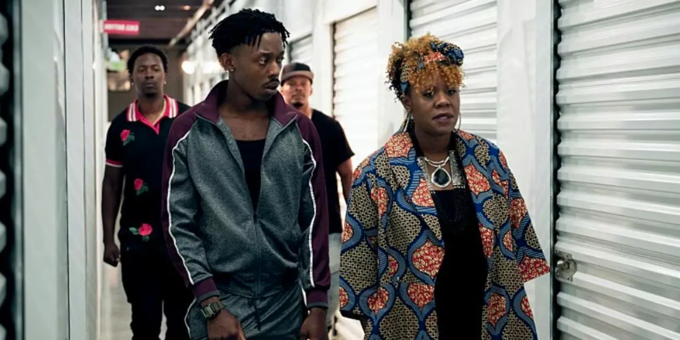 Big Mo (Andrene Ward-Hammond) and Little Mo (Keith Machekanyanga) walking together through storage lockers in Your Honor. Image