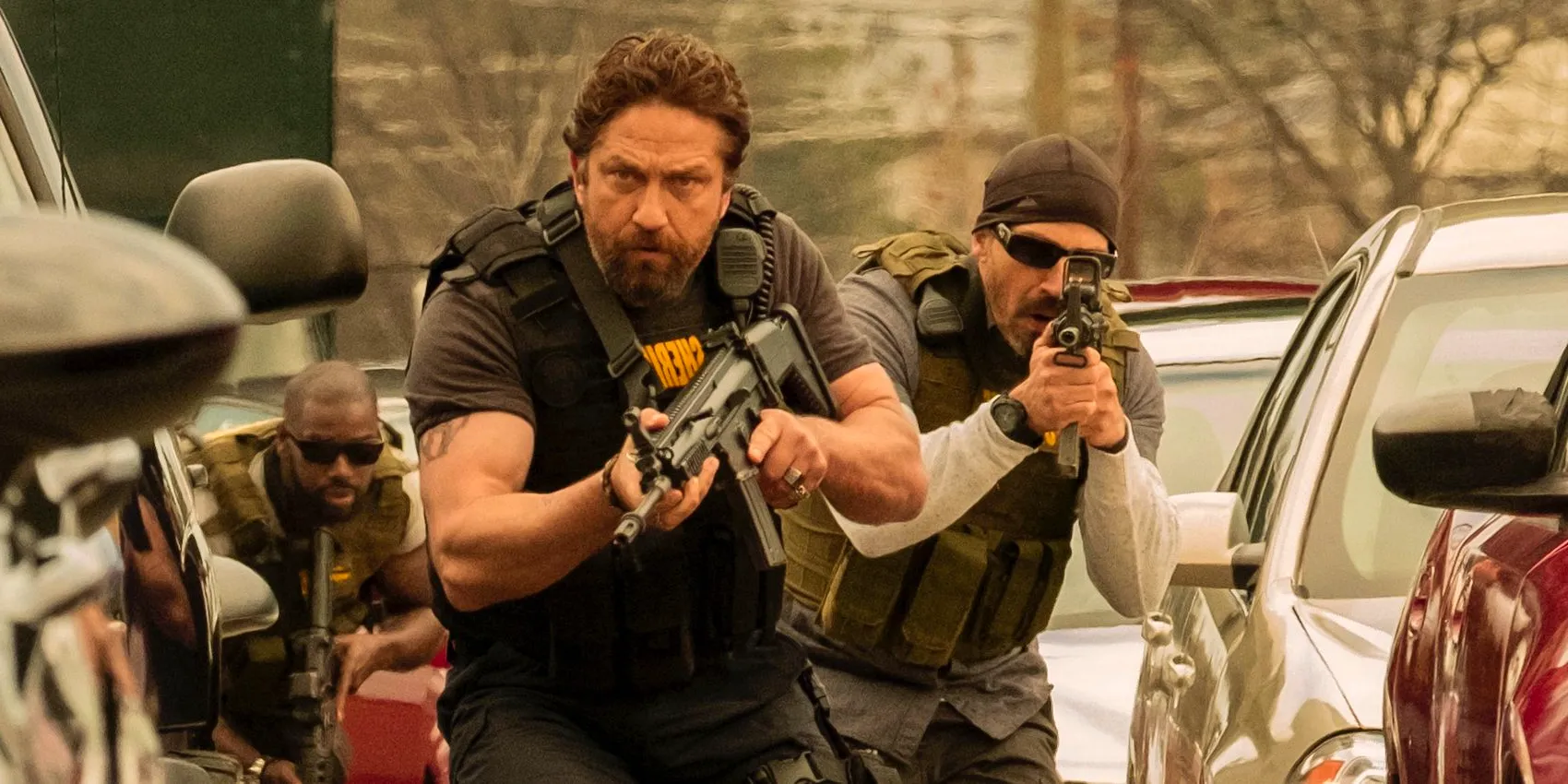 Big Nick holding a gun and walking in Den of Thieves. Image