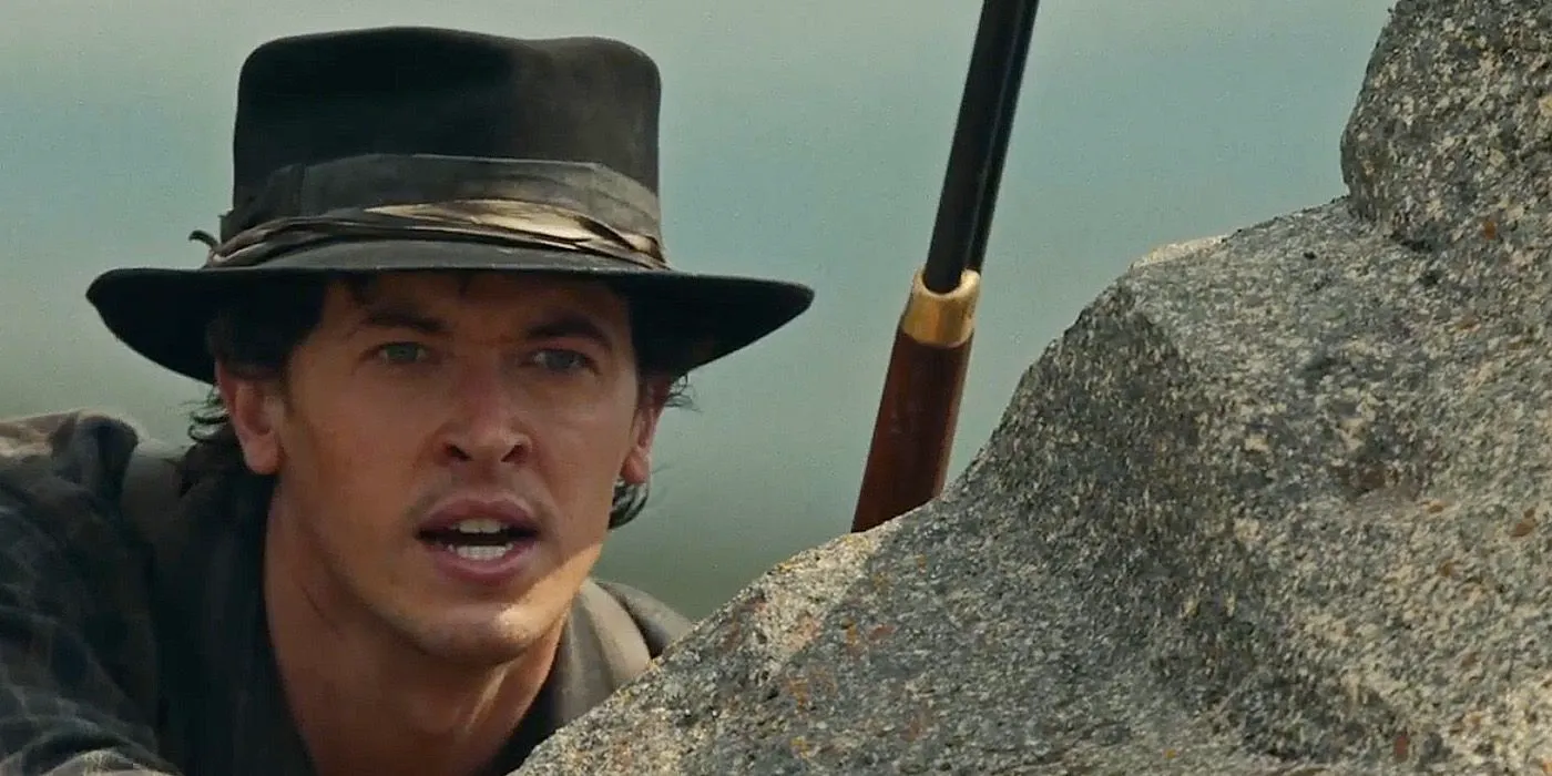 Billy the Kid with a gun looking over a rock season 2 episode 3 Image