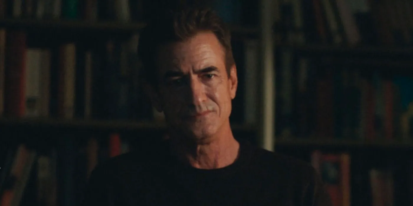 Blackwater Lane Dermot Mulroney against library stack of books, looking concerned  Image