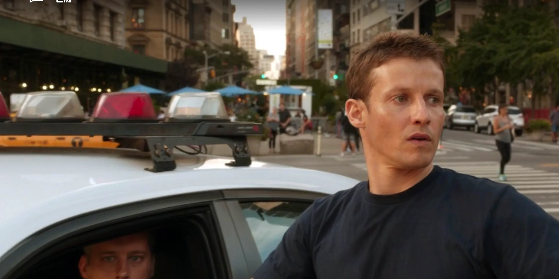 Blue Bloods Jamie asks a cop for a favor at his squad car Image