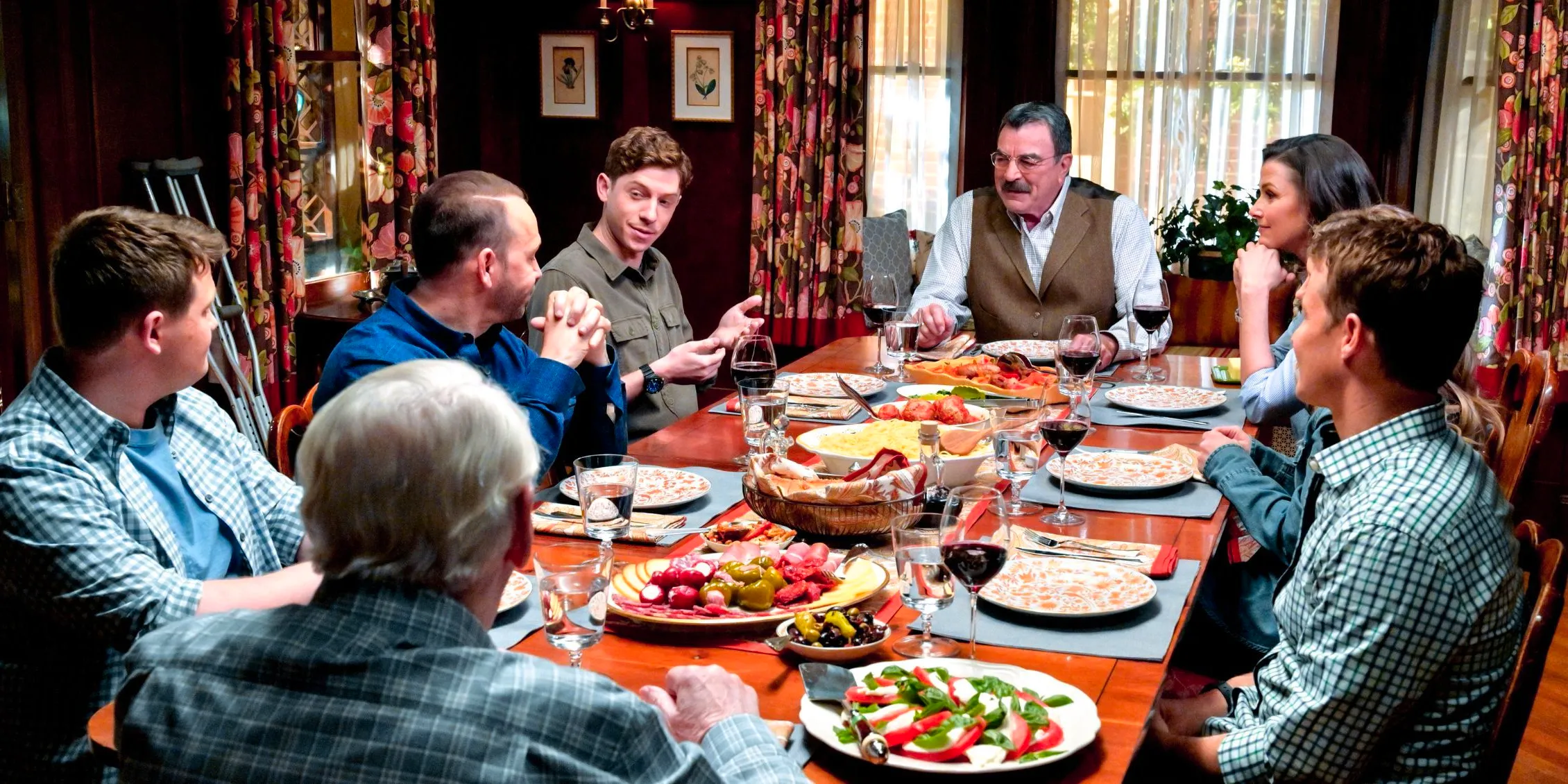 Blue Bloods Joe is on Frank's right making a point while the family gets ready to say Grace Image