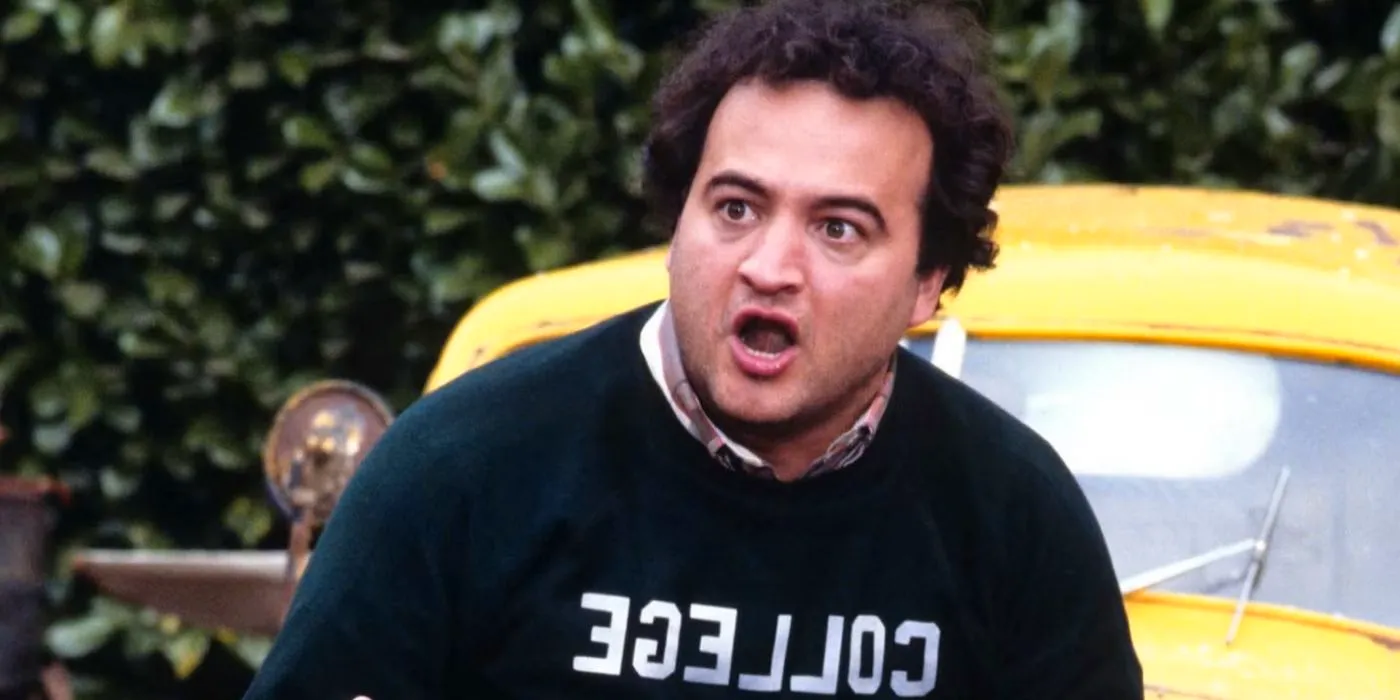 Bluto by a car in Animal House, John Belushi with a college sweatshirt on Image