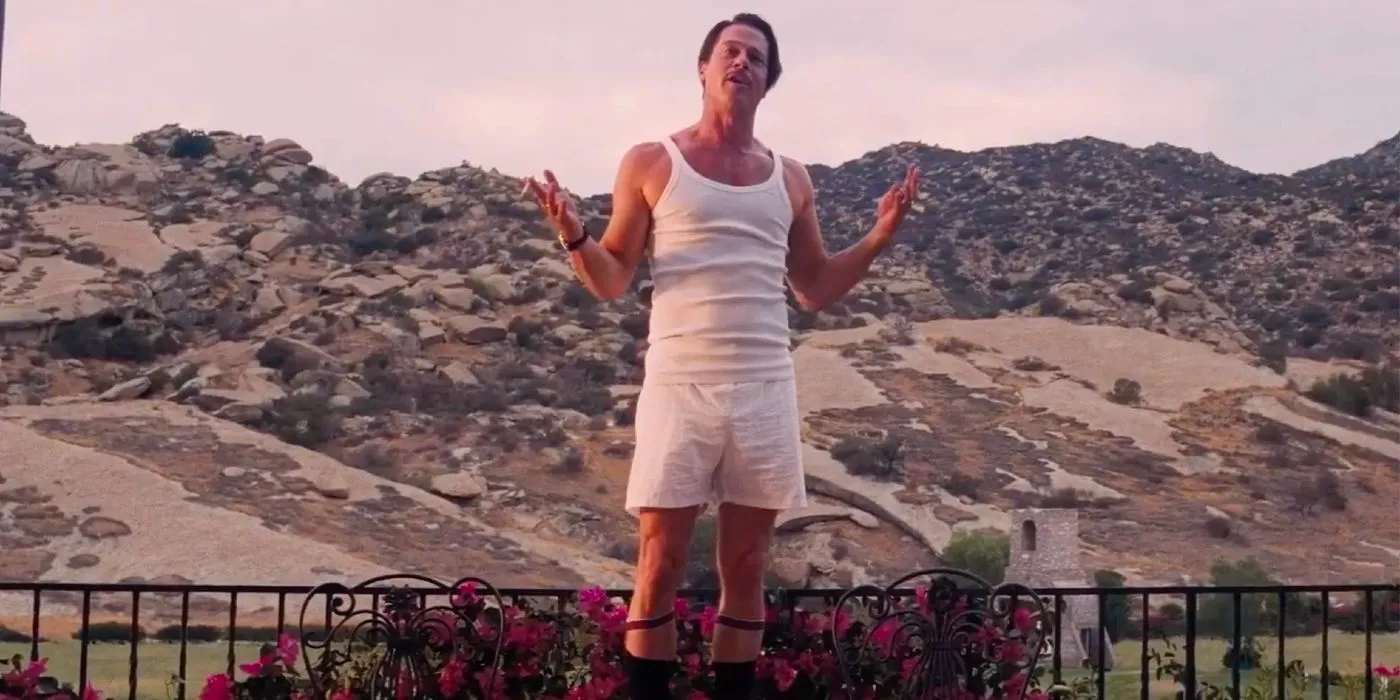 Brad Pitt stands on the balcony in front of a rocky landscape in Babylon Image