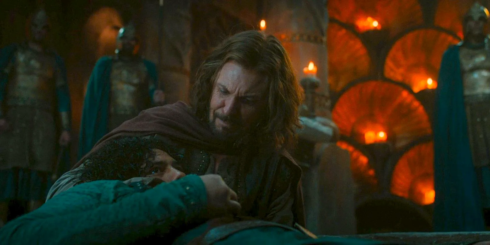 Captain Elendil (Lloyd Owen) witrh Valandil in his arms as he is about to die in The Lord of the Rings: The Rings of Power Season 2 Episode 5 Image