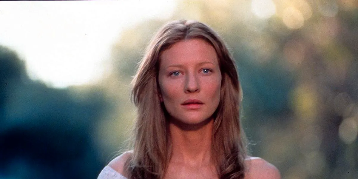 Cate Blanchett in The Gift wearing a soft expression, her hair down in a forest area Image