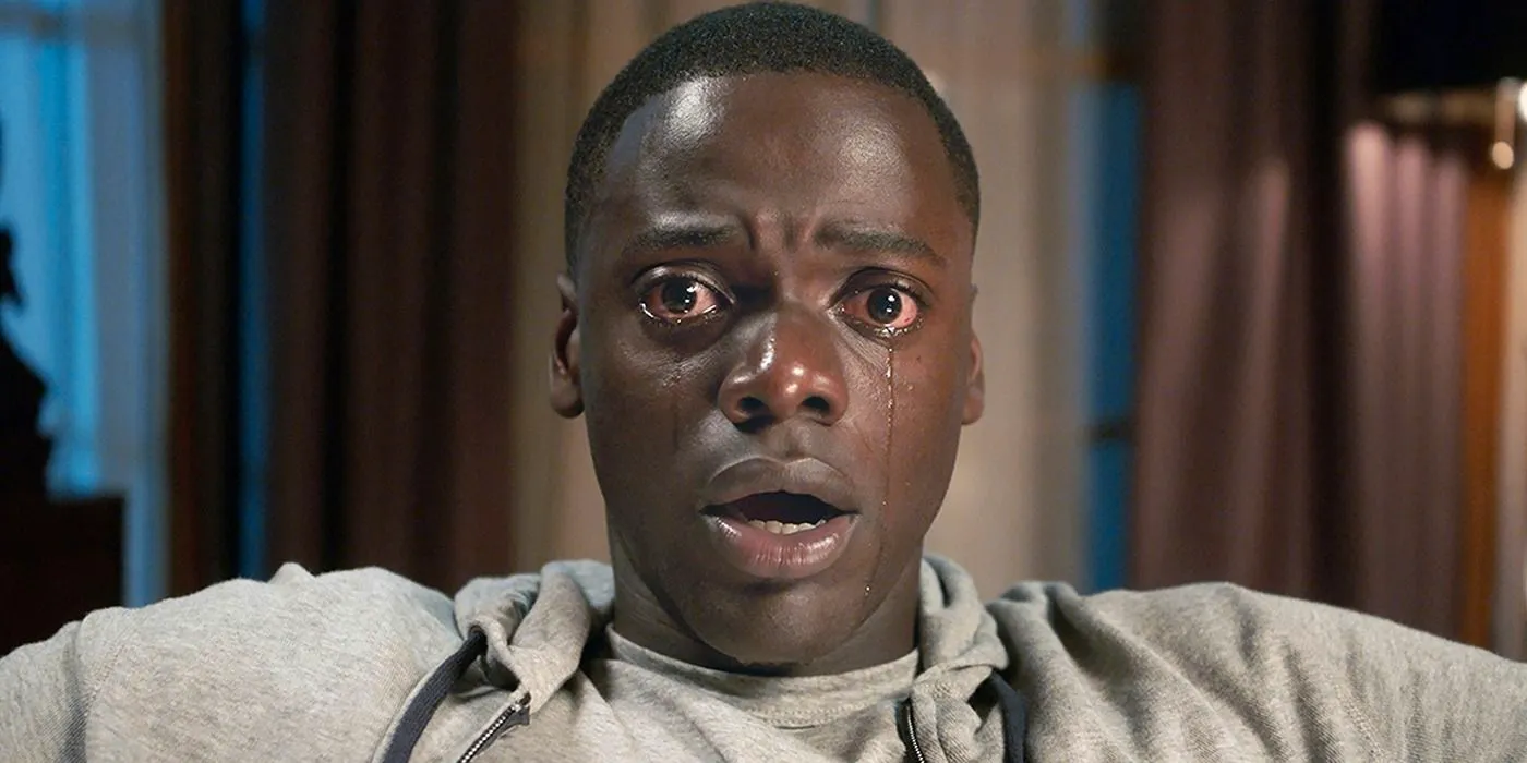 Chris (Daniel Kaluuya) staring ahead and in tears in Get out Image