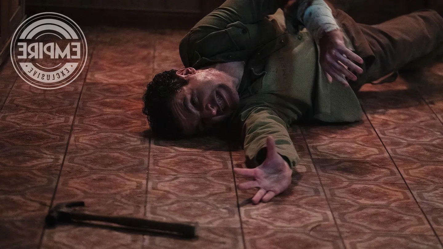 Christopher Abbott reaching for a hammer on the ground as Blake in Wolf Man Image