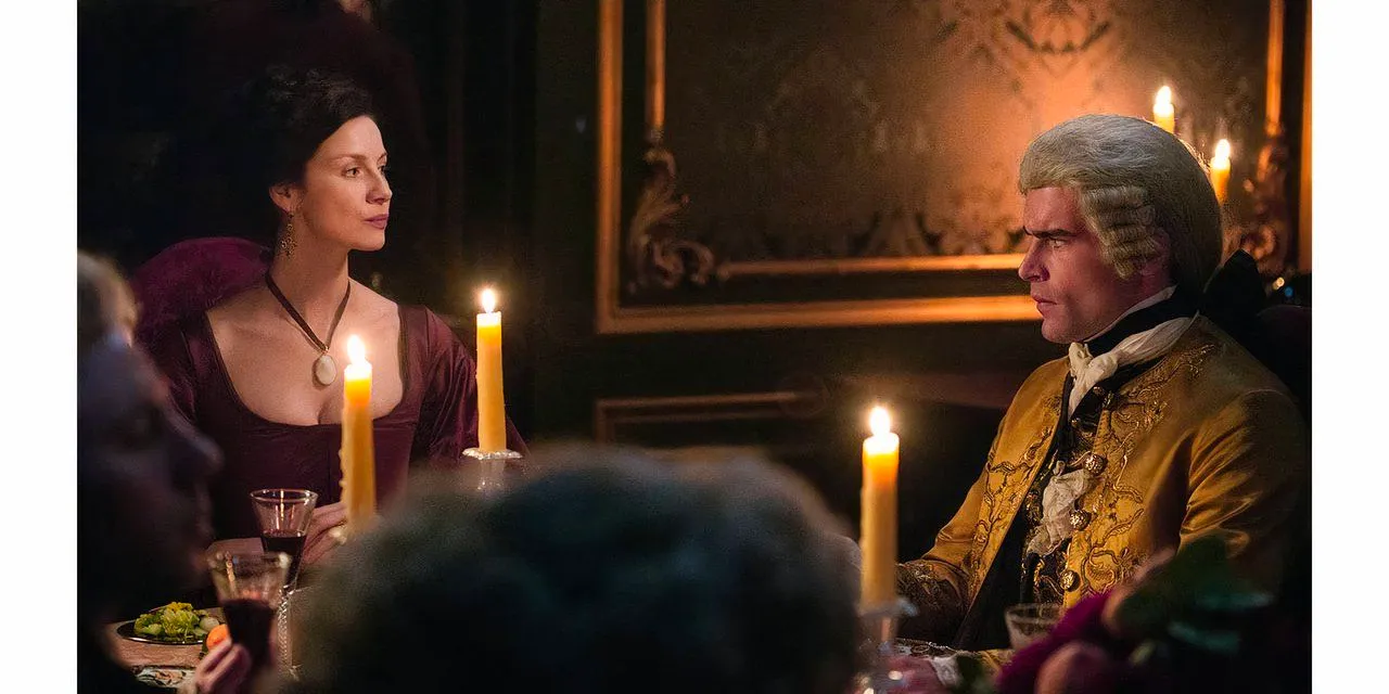 Claire Fraser sits next to Count St. Germain in season 2 of Outlander in Paris. Image